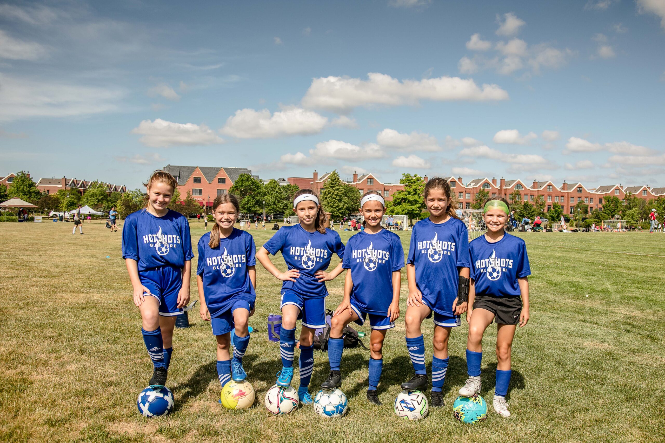 Six female players posing on the soccer field.